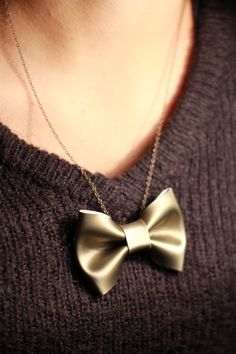 a close up of a person wearing a necklace with a large bow tie on it