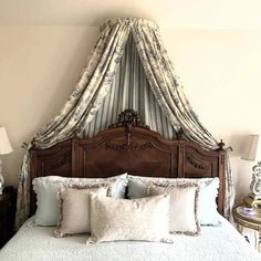 a bed with blue sheets and pillows in a bedroom next to two lamps on either side of the bed