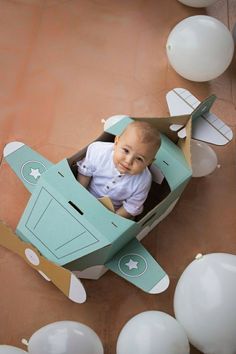 a baby is sitting in a paper airplane