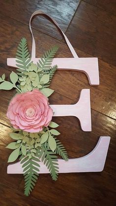 a wooden letter with flowers and leaves on it