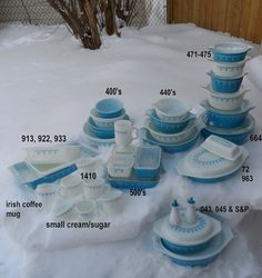 a collection of blue and white dishes in the snow