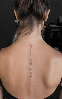 the back of a woman's neck with tattoos on her upper and lower back