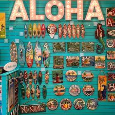 there is a sign that says aloha on the side of a wall covered in magnets