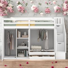 a white bunk bed sitting next to a wall with flowers hanging from it's sides