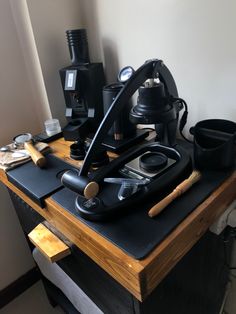 a black ironing board sitting on top of a wooden table next to other items