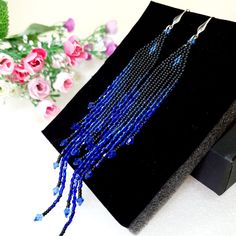 My new very long earrings.Earrings are made of matte black and royal blue seed beads and dangling crystals. This bead sparkles and shimmers. These are very long earrings. Earrings length 6 inches.Weight per earring 6 g.                                                                                                                                                    .These earrings have an irregular stepped shape.They go well with a cocktail dress, The photo does not convey the luster of the Earrings, watch the video. Long Drop Beaded Fringe Earrings For Party, Party Long Drop Earrings With Beaded Fringe, Elegant Blue Tassel Earrings With Beaded Fringe, Blue Fringe Beaded Earrings For Party, Long Drop Tassel Earrings With Dangling Beads For Party, Party Tassel Earrings With Dangling Beads, Beaded Fringe Chandelier Earrings For Party, Blue Faceted Beads Beaded Earrings For Party, Blue Faceted Beads Earrings For Party