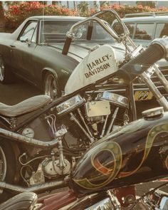 a harley davidson motorcycle parked in a parking lot next to other motorcycles and cars on the street