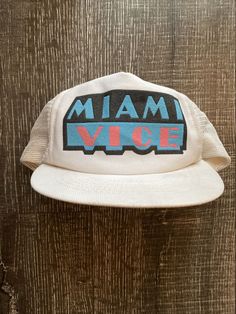 Vintage Miami Vice Snapback Baseball Hat Cap 1980's TV Show w/ Mesh Back. Retro 5-panel Hat With Letter Print, Retro Dad Hat With Curved Brim, Vintage Trucker Hat With Flat Brim For Streetwear, Vintage Style Snapback Hat With Letter Print For Streetwear, Retro Visor Snapback Hat One Size Fits Most, Vintage White Dad Hat, Vintage Flat Brim Hat With Letter Print, Vintage Flat Brim Trucker Hat For Streetwear, White Retro Baseball Cap For Streetwear