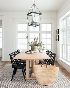 a dining room table with black chairs and a basket