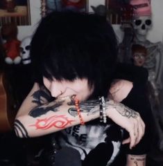 a man with black hair and tattoos on his arm