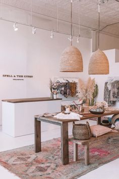 the interior of a clothing store with hanging lights and rugs on the floor in front of it