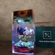 a glass case with some fake animals in it next to a box that says real artisan studios