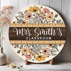 a wooden sign that says, mrs smith's classroom with flowers and rulers on it