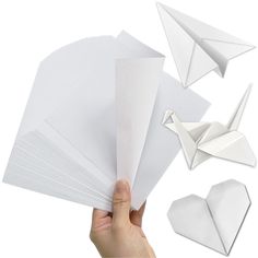 a hand is holding several pieces of paper and an origami bird