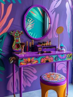 a vanity with a mirror and stool in front of a purple wall painted with tropical leaves