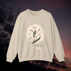 Design: Experience the ultimate Halloween comfort with our "Spooky Surfer Skeleton" sweatshirt! This unique design features a happy skeleton surfing a giant wave surrounded by birds and a large moon in the background. Perfect for anyone who loves the beach and wants to celebrate the spookiness of Halloween. This sweatshirt is a must-have for the upcoming Halloween season! Perfect Gift: Ideal for Halloween parties, fall beach trips, or as a fun everyday outfit. Versatile: Perfect for the cool fal Happy Skeleton, Crew Neck T-shirt For Surfing, Sporty Crew Neck T-shirt For Surfing, Cool Ghost, Graphic Print Crew Neck T-shirt For Surfing, Surfing Crew Neck T-shirt With Sublimation Print, Tropical Crew Neck T-shirt For Surfing, Giant Waves, Skeleton Sweatshirt