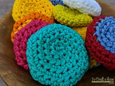 crocheted dishcloths in a wooden bowl on top of a wood table