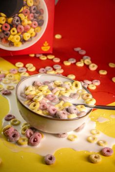 a bowl filled with cereal sitting on top of a table next to a red box