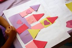 the child is cutting out hearts on paper