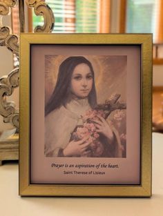 an image of the immaculate mary holding flowers in front of a mirror with words on it