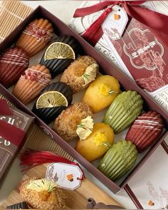 two boxes filled with assorted pastries on top of a table