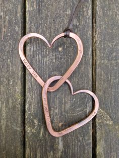 two heart shaped key chains hanging on a wooden surface