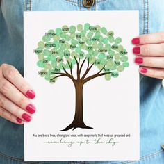 a woman holding up a card with a tree on it