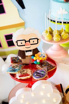 an old man with glasses is standing in front of a table full of desserts