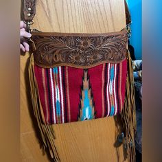 Life's Too Short To Not Make A Statement With This Gorgeous Arizona Saddle Blanket Crossbody Handcrafted From Genuine Leather. You'll Be Turning Heads With The Beautiful Natural Colors That Pop Against The Textured Tooled Leather Design. Rock It Like A Boss Lady And Show The World Your Style - Because You're Worth It!! Dimensions: 15in X 15in Used Maybe Twice! In Excellent Condition! Multicolor Hand Tooled Travel Bags, Red Hand Tooled Bag For Daily Use, Hand Tooled Red Rectangular Bag, Red Hand Tooled Rectangular Bag, Red Hand-tooled Rectangular Bag, Red Hand Tooled Shoulder Bag For Daily Use, Hand Tooled Crossbody Travel Bag, You're Worth It, Life's Too Short