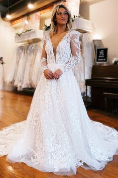 a woman in a white wedding dress standing on a wooden floor