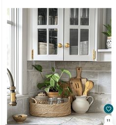 a kitchen with white cabinets and wooden utensils in a basket on the counter