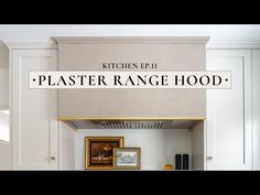 a kitchen with white cabinets and a sign that says plaster range hood