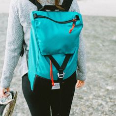 a woman wearing a blue backpack and black leggings