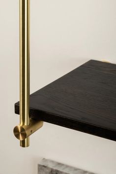 a black and gold shelf with two brass handles