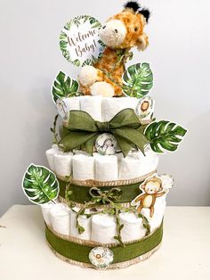 Diaper cake made with safari cut outs and leaf ribbon. Topped off with a stuffed giraffe. Safari Shower Ideas, Diaper Cake Ideas, Lion Baby Shower, Idee Babyshower, Baby Shower Theme Decorations