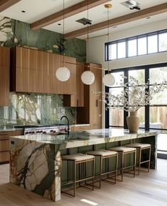 a large kitchen with marble counter tops and wooden cabinets, along with an island in the middle