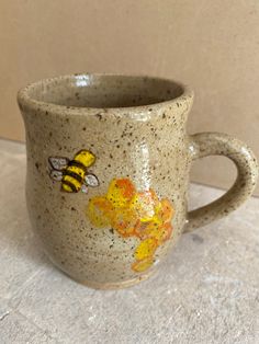 a ceramic mug with bees painted on it