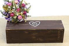 a wooden box with flowers in it and a sticker on the lid that says love