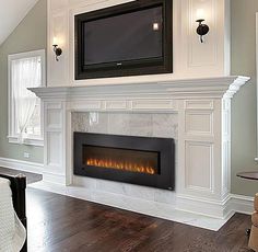 a living room with a tv mounted on the wall above a fire place in front of a fireplace