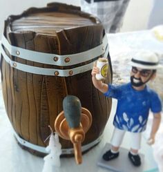 a figurine is next to a wooden barrel with a man holding a beer