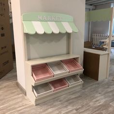 a toy store display case with pink and green trays on the bottom shelf next to it