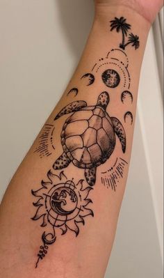 a tattoo on the arm of a woman with a turtle and sun, moon and stars