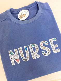 Show up to the hospital in style wearing this adorable nurse inspired embroidered sweatshirt. This design features a white stitching on a blue sweatshirt with the word nurse in applique. Materials: 80% Cotton 20% Polyester Shipping Each embroidered sweatshirt is handmade to order & may have a processing time of up to 14 days. If this sweatshirt is ordered with other items, the entire order will ship together. If you need your other items sooner, you may want to place multiple orders. This item is final sale. Healthcare Appreciation, Nurse Embroidery Designs, Back Stitch Embroidery, Appliqué Sweatshirt, Applique Sweatshirt, Nursing Hoodie, Sewing School, Reverse Applique, Cute Nurse