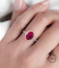 a woman's hand with a ring on it and a pink stone in the middle