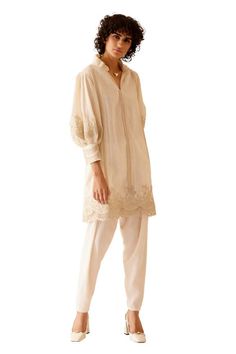 Ivory Tunic featuring floral lace pattern on the sleeves, hem with side pockets and pleat detailing on the back. - Aza Fashions Elegant Spring Kurta With Embroidered Sleeves, Spring Elegant Kurta With Embroidered Sleeves, Elegant Beige Sets With Lace Work, Elegant Off White Kurta For Spring, Elegant Beige Kurta With Floral Embroidery, Elegant Beige Kurta For Spring, Floral Lace Pattern, Lace Ruffle, Lace Pattern