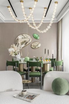 an elegant dining room with green chairs and gold accents on the walls, along with white couches