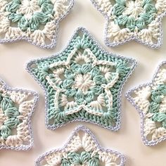 four crocheted snowflakes are arranged on a table