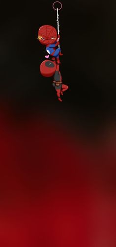 a spiderman hanging from a string in the air