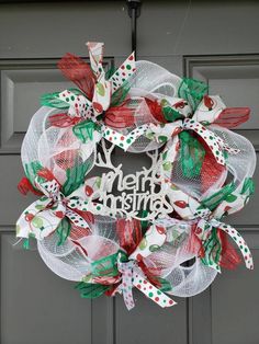 a christmas mesh wreath hanging on the front door