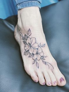 a woman's foot with a flower tattoo on it